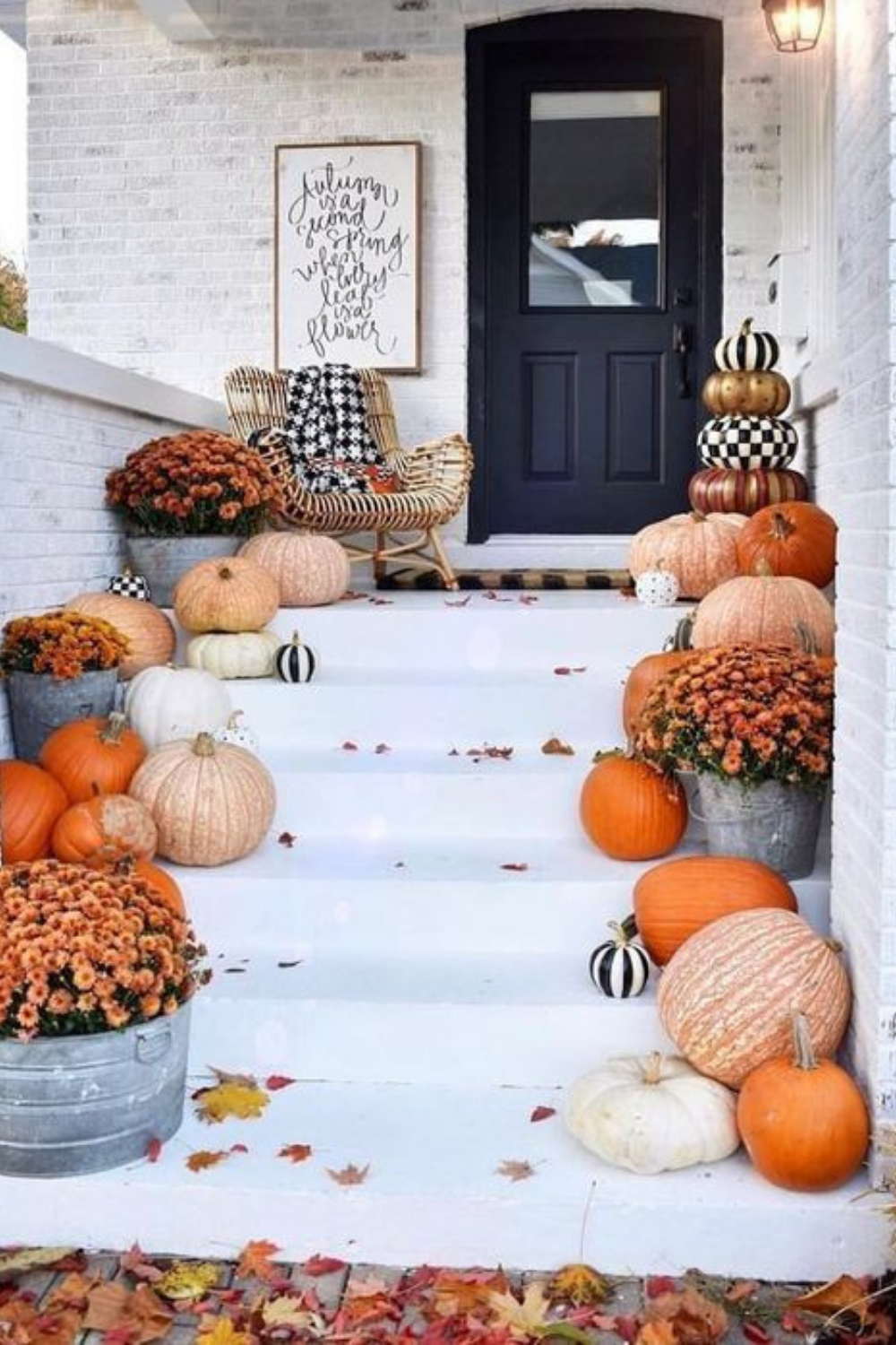 Front porch with white steps, lined with pumpkins and flowers