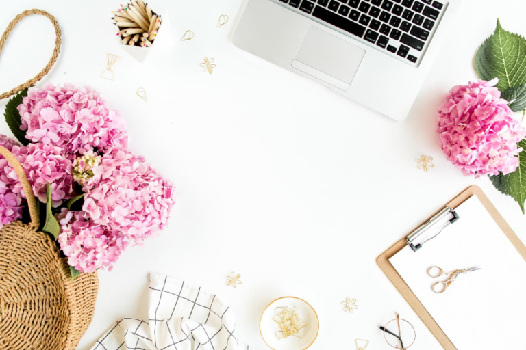 White table with pink flowers and laptop