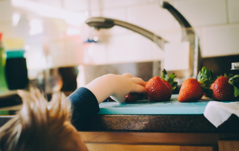 Kiddo grabbing a strawberry