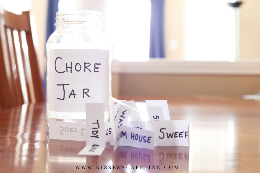 Jar on a table labeled Chore Jar with papers around it that have chores written on them