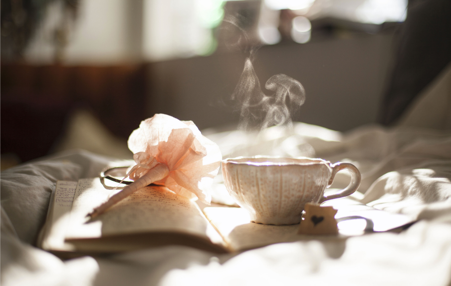 Cup of tea and pretty pen with journal