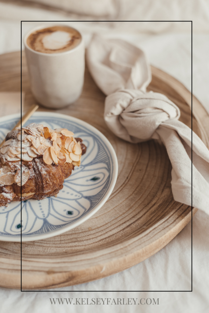 Tray with a scone on a plate, cup of coffee and a knotted napkin