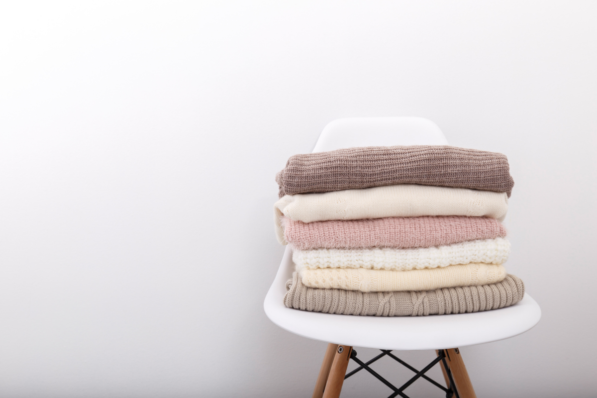 A chair with sweaters folded on top