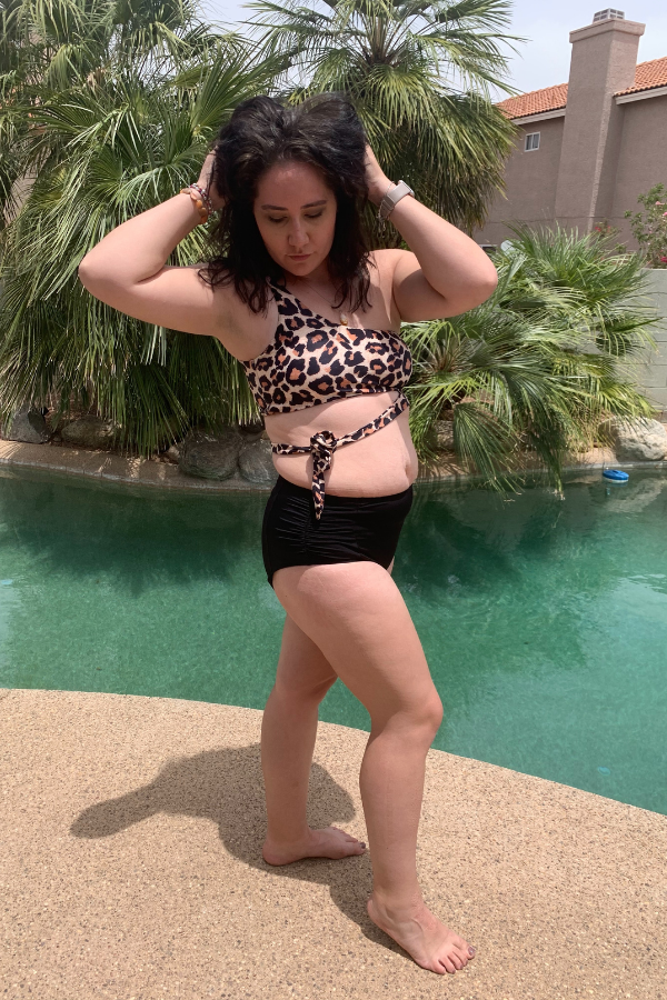 Standing near pool in leopard bathing suit, holding up my hair