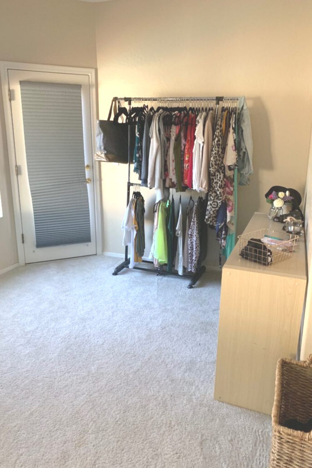 Clothing rack full of clothes and a low shelf with decor items on the top