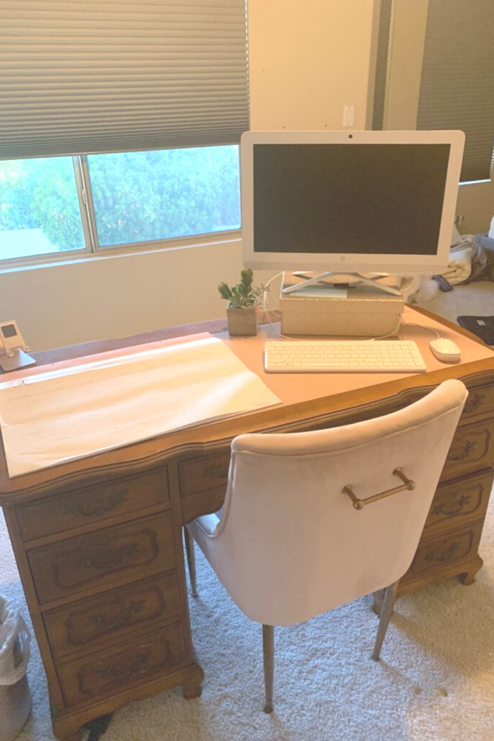 Pink chair in front of a brown desk with a white computer on top