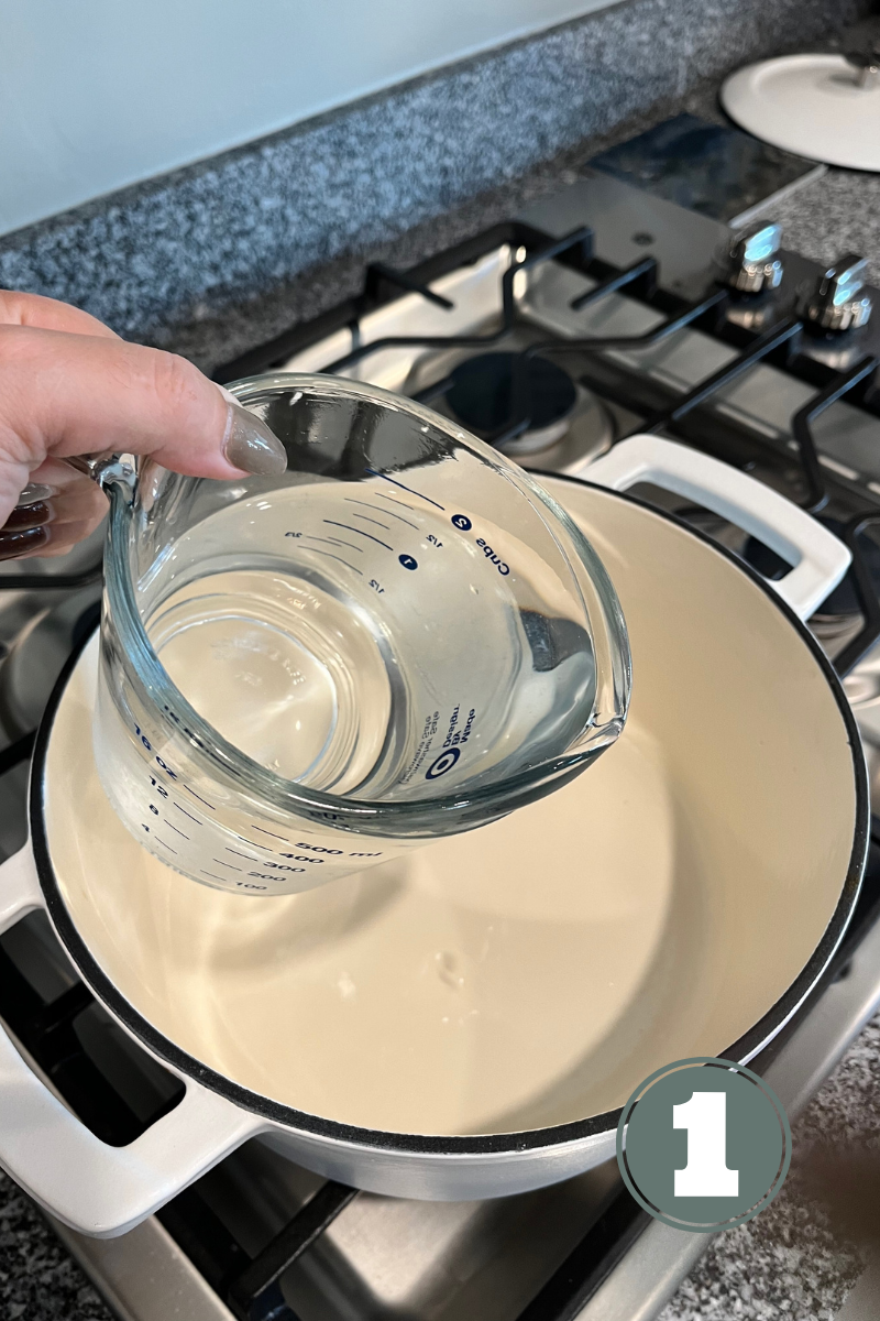 Hand pouring water into a pot