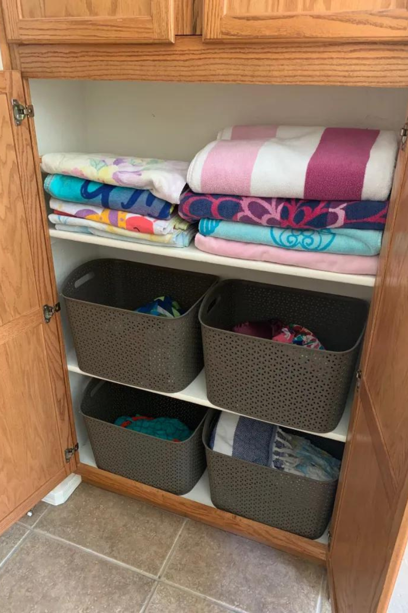 Linen closet full of folded towels and brown baskets