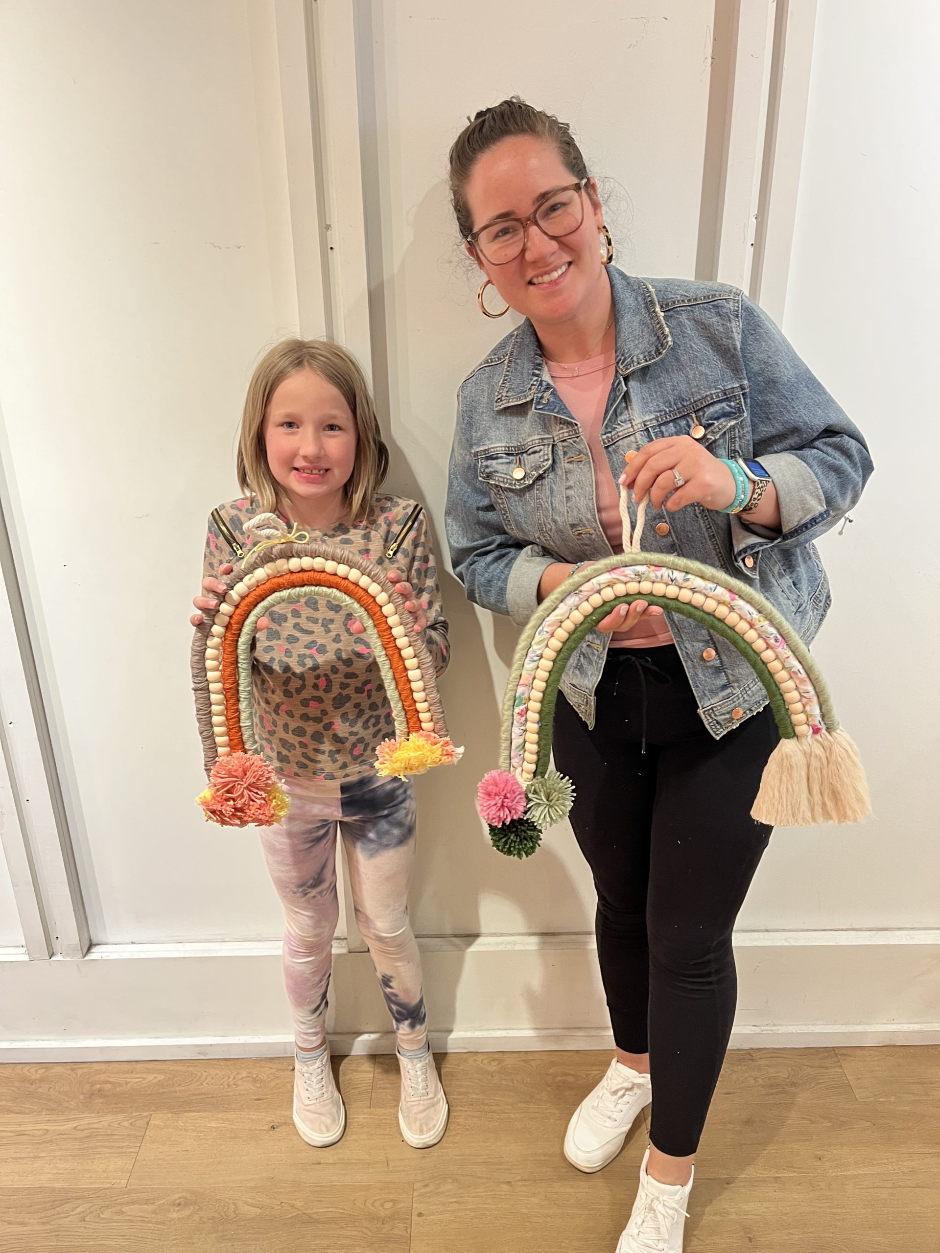 My daughter and I holding our yarn rainbows